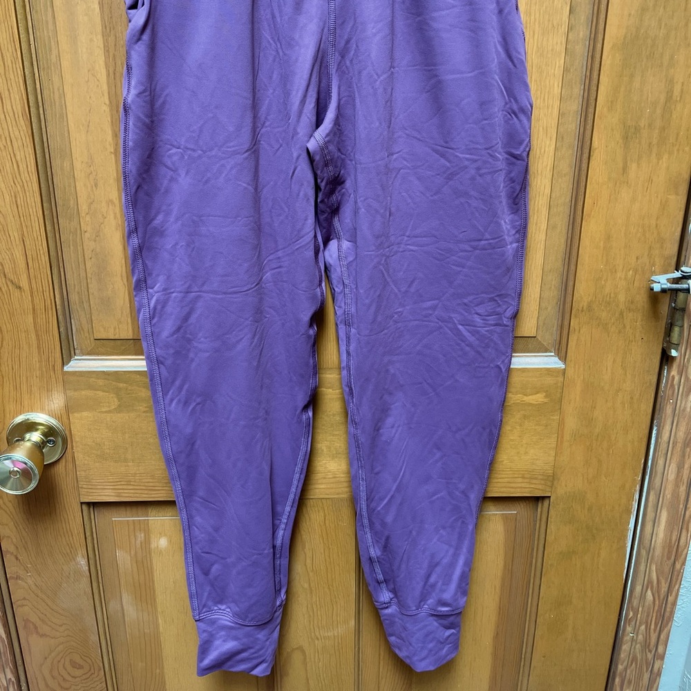 Women’s Under Armour fitted joggers in ash plum, size small.
